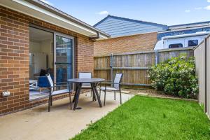 a patio with a table and chairs and a fence at Charming 2-Bed Moss Vale Getaway in Moss Vale