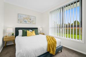 ein Schlafzimmer mit einem Bett und einem großen Fenster in der Unterkunft Charming 2-Bed Moss Vale Getaway in Moss Vale