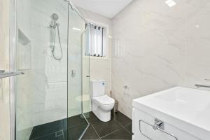 ein Bad mit einer Dusche, einem WC und einem Waschbecken in der Unterkunft Charming 2-Bed Moss Vale Getaway in Moss Vale