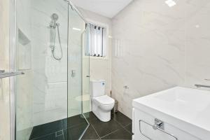 a bathroom with a shower and a toilet and a sink at Charming 2-Bed Moss Vale Getaway in Moss Vale