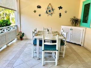 una sala da pranzo con tavolo e sedie bianchi di La Dolce Vita Beachfront Apt 2 a Las Terrenas