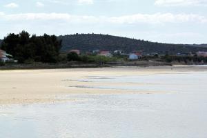 una spiaggia con una montagna sullo sfondo di Holiday house with a swimming pool Ljubac, Zadar - 22537 a Krneša