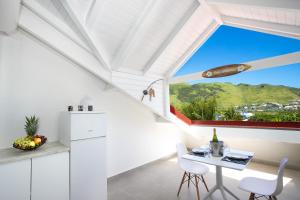 una cucina bianca con tavolo e una grande finestra di Beautiful suite S12 with pool and sea view a Cul de Sac