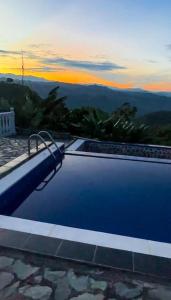 a blue swimming pool with a view of the mountains at Villa Tikuna in Mariquita