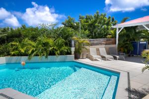 a swimming pool in a backyard with chairs and trees at Beautiful suite S12 with pool and sea view in Cul de Sac