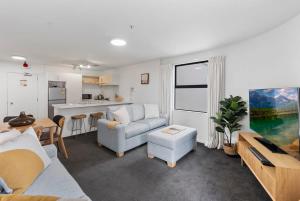 a living room with a couch and a table at Beach Views at Oceanside in Mount Maunganui