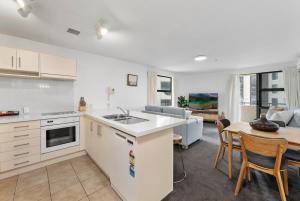 a kitchen and living room with a table and chairs at Beach Views at Oceanside in Mount Maunganui