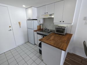 a kitchen with white cabinets and a sink and a stove at Bienvenue chez Alice et daniel in Saint-Férréol-les-Neiges