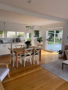 eine Küche und ein Esszimmer mit einem Tisch und Stühlen in der Unterkunft Kingston Beach Home - Beach & Bush Views in Kingston Beach
