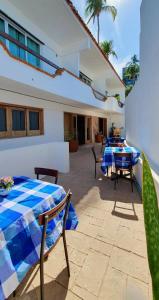 a patio with a table and chairs and a house at Hill House Mazatlan - Bed & Breakfast in Mazatlán