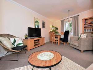 ein Wohnzimmer mit einem TV und einem Tisch in der Unterkunft 3 bed in Bampton 77931 in Bampton