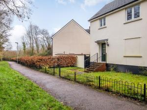 ein weißes Haus mit einem Zaun davor in der Unterkunft 3 bed in Bampton 77931 in Bampton