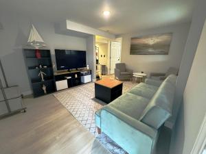a living room with a couch and a flat screen tv at Seaside Serenity: Cozy Retreat on Bay Drive in Kill Devil Hills