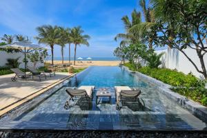 piscina con sedie e spiaggia di Melia Ho Tram Beach Resort a Ho Tram