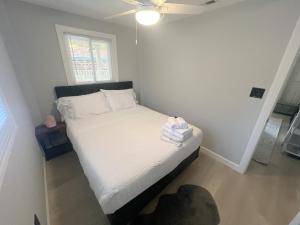 a small bedroom with a bed with white sheets at Seaside Serenity: Cozy Retreat on Bay Drive in Kill Devil Hills