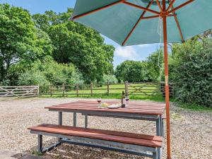 a picnic table with a green umbrella and a bench at 3 bed property in Sturminster Newton Dorset RCORN in Sturminster Newton