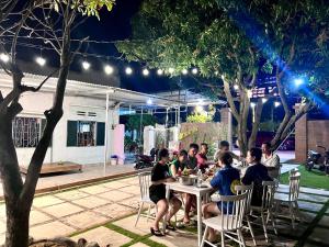 a group of people sitting at a table at night at Motel An Bình in Dien Khanh