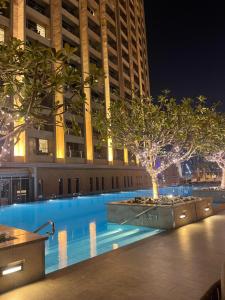 a swimming pool with a tree in front of a building at Emaar Residences Fashion Avenue - Formerly Address Dubai Mall in Dubai