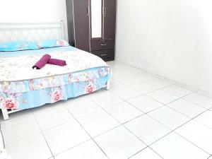 ein Schlafzimmer mit einem Bett mit einem lila Bademantel. in der Unterkunft HOMESTAY NAFISAH in Tapah Road