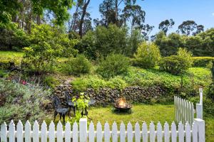 uma cerca branca em frente a um jardim com lareira em Lush and Charming Country Escape, Stunning Gardens em Colo Vale
