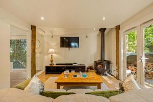 uma sala de estar com uma mesa e uma lareira em Arnica Views Summit Retreat em Mount Dandenong