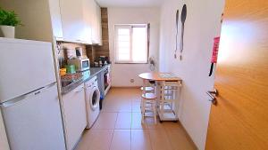 a kitchen with a refrigerator and a table in it at Gardunha Apartments 3º Direito in Fundão