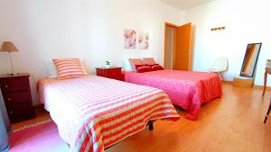 a bedroom with two beds and a wooden floor at Gardunha Apartments 3º Direito in Fundão