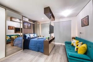 - une chambre avec un lit bleu et un canapé bleu dans l'établissement Rover Centro, à São Paulo