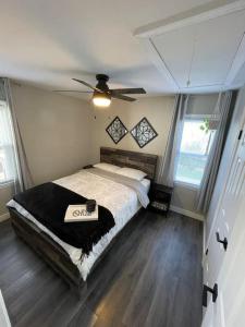sypialnia z łóżkiem i wentylatorem sufitowym w obiekcie Cozy Mosaic Cottage w mieście Eastlake
