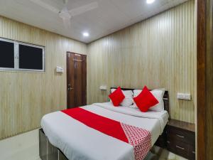 sypialnia z dużym łóżkiem z czerwonymi poduszkami w obiekcie Super OYO Flagship Hotel Diamond w Bombaju