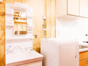 a white bathroom with a sink and a washing machine at MOBILITA COURT IWATE in Hachimantai