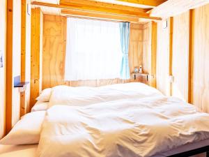 a large bed in a room with a window at MOBILITA COURT IWATE in Hachimantai