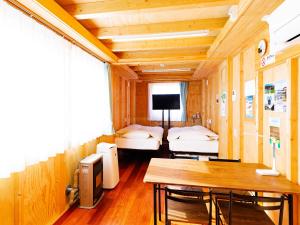 a room with two beds and a table in it at MOBILITA COURT IWATE in Hachimantai