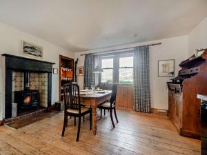 a dining room with a table and chairs and a fireplace at 2 Bed in Lochranza 77882 in Lochranza