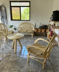 um quarto com três cadeiras, uma mesa e uma janela em 4 Elementos Hostal em San Juan La Laguna