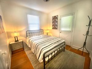 a bedroom with a bed with two lamps and two windows at Bogus Property in Salt Lake City