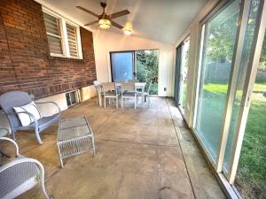 a screened in porch with chairs and a ceiling fan at Bogus Property in Salt Lake City