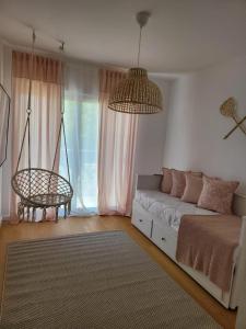 ein Wohnzimmer mit Sofa und Schaukel in der Unterkunft The Albufeira Concierge - Prime Sunset Design in Albufeira