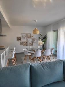 ein Wohnzimmer mit einem Sofa, einem Tisch und Stühlen in der Unterkunft The Albufeira Concierge - Prime Sunset Design in Albufeira