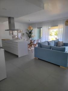 ein Wohnzimmer mit einem blauen Sofa und einer Küche in der Unterkunft The Albufeira Concierge - Prime Sunset Design in Albufeira