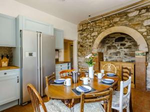 uma cozinha com uma mesa de madeira e um frigorífico em 5 Bed in Achnasheen 83017 em Achnasheen