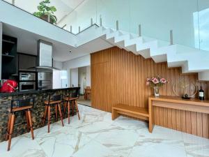 a kitchen with a staircase and a counter with stools at CASA LIMA, nossa casa na represa in Itaí