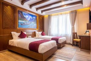 a hotel room with two beds and a desk at Kailash Boutique Hotel in Kathmandu