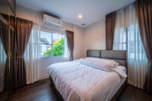 a bedroom with a bed and a large window at 20min to City Bloomsbury Ramintra Luxury Family Big House in Bang Khen +40 photos