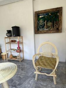 una stanza con una sedia e un dipinto sul muro di 4 Elementos Hostal a San Juan La Laguna