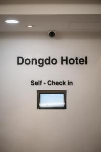 a sign for a hotel with a window on a wall at SSH Myeongdong Dongdo Hostel in Seoul