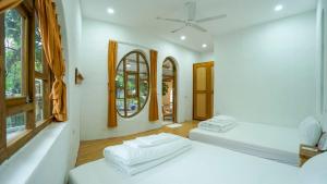 ein weißes Zimmer mit 2 Betten und einem Spiegel in der Unterkunft Bavi Myan Maison 