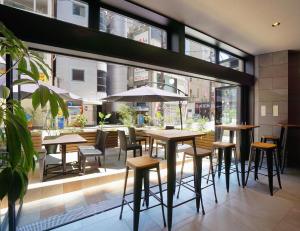 神戸市にあるホテルSUI神戸三宮 by ABESTのテーブルと椅子、窓のあるレストラン