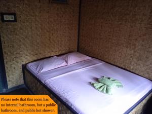 un piccolo letto con un animale di peluche verde sopra di Yoschi's Hotel Bromo a Ngadisari