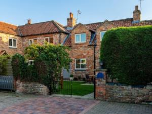 a brick house with a gate in front of it at 5 Bed in York 77267 in Green Hammerton